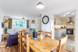 a dining room and kitchen with a wooden table and chairs at Maunsell - Charming 3 bedroom house in Ashford central location for contractors or families, sleeps 6 in Ashford