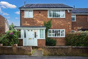 a red brick house with a white garage at Maunsell House - Lovely central home near Designer Outlets & town with parking in Ashford