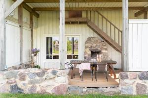 a porch with a table and a stone fireplace at Roose City House in Kärdla