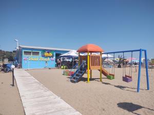 un parco giochi sulla spiaggia accanto a un edificio di Loli’s Beach Studio a Burgas