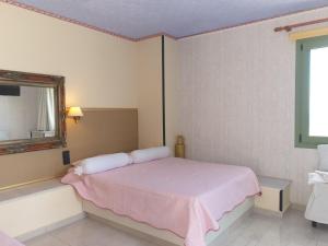 a bedroom with a bed and a mirror and a window at Executive Junior Suite in Hersonissos