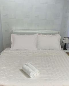 a white bed with two rolled towels on it at Hoang Tuan Hotel in Ho Chi Minh City