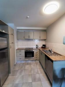 a kitchen with a sink and a stove top oven at The Anchorage Apartments in Mount Maunganui