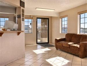 a living room with a brown couch in a room at Super 8 by Wyndham Lake Havasu City in Lake Havasu City
