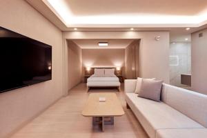 ein Wohnzimmer mit einem Sofa und einem Bett in der Unterkunft Tops10 Resort Donggang Cistar in Yeongwol