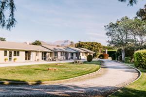 a house on a street with a driveway at Flaxbourne Motels in Ward