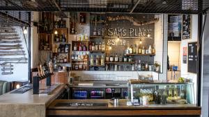 a bar with bottles of alcohol on the wall at Woopi Backpackers in Woolgoolga