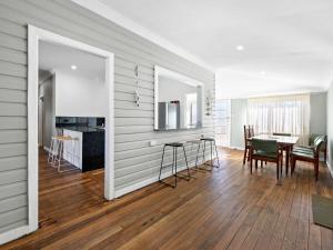 a kitchen and dining room with a table and chairs at Salty Sea Cottage in Narooma