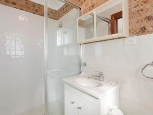 
a bathroom with a sink, mirror, and toilet at Sapphire Waters Unit 5 in Narooma
