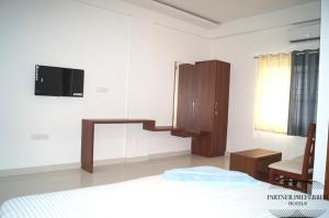 a bedroom with a bed and a desk and a television at PPH Living BSK Deluxe in Bangalore