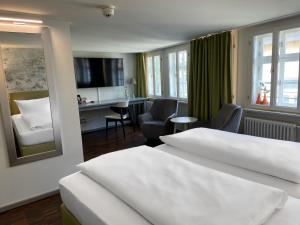 a hotel room with two beds and a desk at Hotel Krämerbrücke Erfurt in Erfurt