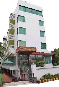 ein hohes weißes Gebäude mit grünem Büro in der Unterkunft Hotel Green Olive in Aurangabad