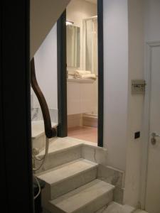 a bathroom with stairs leading into a bathroom with a mirror at La Casa sui Tetti in Genoa +15 photos