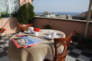 una mesa en un balcón con vistas al océano en La Casa sui Tetti en Génova