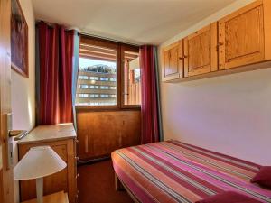 a small bedroom with a bed and a window at Appartement La Plagne, 2 pièces, 5 personnes - FR-1-455-56 in La Plagne