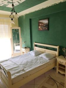 - une chambre dotée d'un lit avec un mur vert dans l'établissement Apartament Onix, à Legian