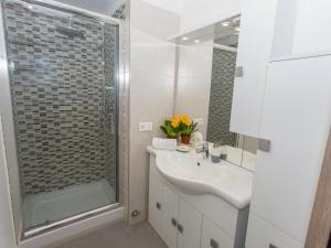 uma casa de banho branca com um chuveiro e um lavatório. em Appartement Menton, 3 pièces, 5 personnes - FR-1-196-230 em Menton