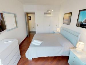 um quarto branco com uma cama e duas mesas de cabeceira em Appartement Menton, 3 pièces, 5 personnes - FR-1-196-230 em Menton