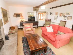 a living room with a red couch and a table at Wray Green in Ravenstonedale