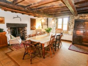 a dining room with a table and chairs and a fireplace at Wray Green in Ravenstonedale