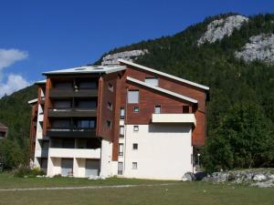 un gran edificio frente a una montaña en Studio Corrençon-en-Vercors, 1 pièce, 4 personnes - FR-1-515-92 en Corrençon-en-Vercors
