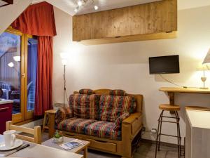 een woonkamer met een bank en een tv bij Appartement Brides-les-Bains, 1 pièce, 4 personnes - FR-1-512-204 in Brides-les-Bains