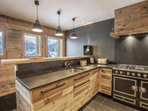 a kitchen with wooden cabinets and a stove at Chalet La Clusaz, 5 pièces, 11 personnes - FR-1-304-229 in La Clusaz