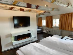 ein Wohnzimmer mit einem Kamin und einem Flachbild-TV in der Unterkunft Hotel Krämerbrücke Erfurt in Erfurt