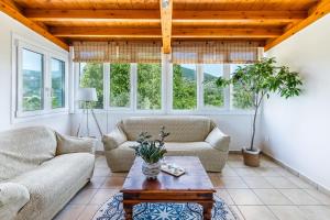 a living room with two couches and a table at Artemis' Garden in Skopelos Town