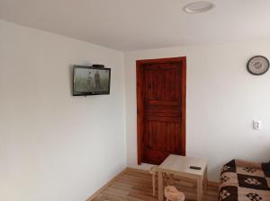a room with a door and a table and a clock at Laki Marjanovic in Zlatibor