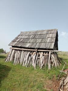 an old wooden barn on a grassy field at Laki Marjanovic in Zlatibor +6 photos