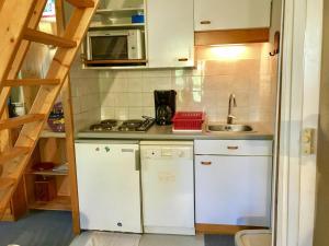 a small kitchen with white cabinets and a sink at Appartement Villard-de-Lans, 2 pièces, 4 personnes - FR-1-515-95 in Villard-de-Lans