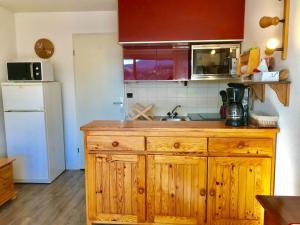 a kitchen with a wooden cabinet and a sink at Studio Villard-de-Lans, 1 pièce, 4 personnes - FR-1-515-68 in Villard-de-Lans