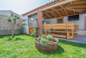 a garden with a wooden bench in a yard at Village holiday apartman with heated pool Maslina in Kostanje