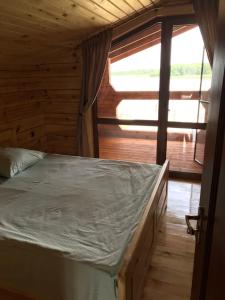 um quarto com uma cama num chalé de madeira em Берег Світязя 2 em Svityazʼ