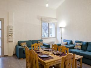 une salle à manger avec une table et un canapé bleu dans l'établissement Appartement Brides-les-Bains, 3 pièces, 6 personnes - FR-1-512-10, à Brides-les-Bains