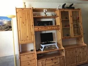 a wooden entertainment center with a television and a computer monitor at Studio Corrençon-en-Vercors, 1 pièce, 4 personnes - FR-1-515-83 in Corrençon-en-Vercors