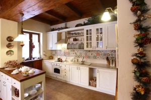a kitchen with white cabinets and a christmas tree at Chalet Kukavica in Zhdenievo
