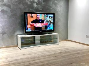 a flat screen tv sitting on a stand in a room at Apartment Light in Stobreč