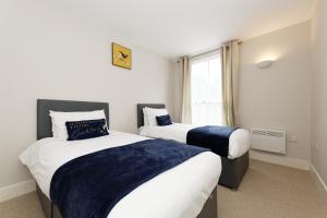 two beds in a small room with a window at Flagstaff Apartment with Secure Parking in Kent