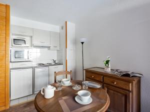 a small kitchen with a wooden table and a dining room at Studio Brides-les-Bains, 1 pièce, 4 personnes - FR-1-512-227 in Brides-les-Bains