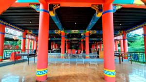 una habitación con columnas rojas y mesas en un edificio en Resort Highlander en Bogor