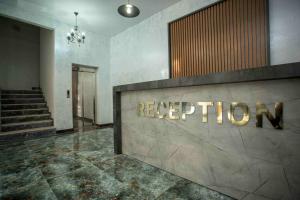 a hotel lobby with a reception sign on the wall at HOTEL LORD in Batumi