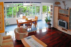 a living room with a table and chairs and a television at Apartments Gilve in Hvar