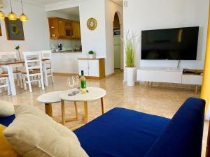 a living room with a couch and a tv at Apartment Costa Lunar in Cabo Roig in Playas de Orihuela