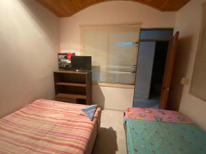 a small bedroom with a bed and a desk at Acogedor y cómoda casa vacacional Condominios Flandes in Flandes +13 photos