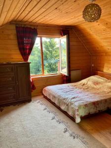 ein Schlafzimmer mit einem Bett in einem Zimmer mit einem Fenster in der Unterkunft Villa nagori in Slawske