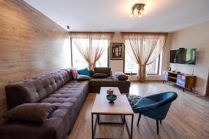 un soggiorno con divano marrone e tavolo di Къща за гости Синята Врана a Mostowo