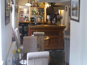 een bar met een tafel en stoelen in een kamer bij 3 Millstones Inn in West Bradford