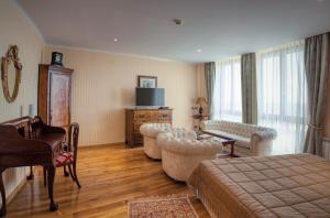 a hotel room with a bed and chairs and a television at Hotel Soli Invicto in Elenovo